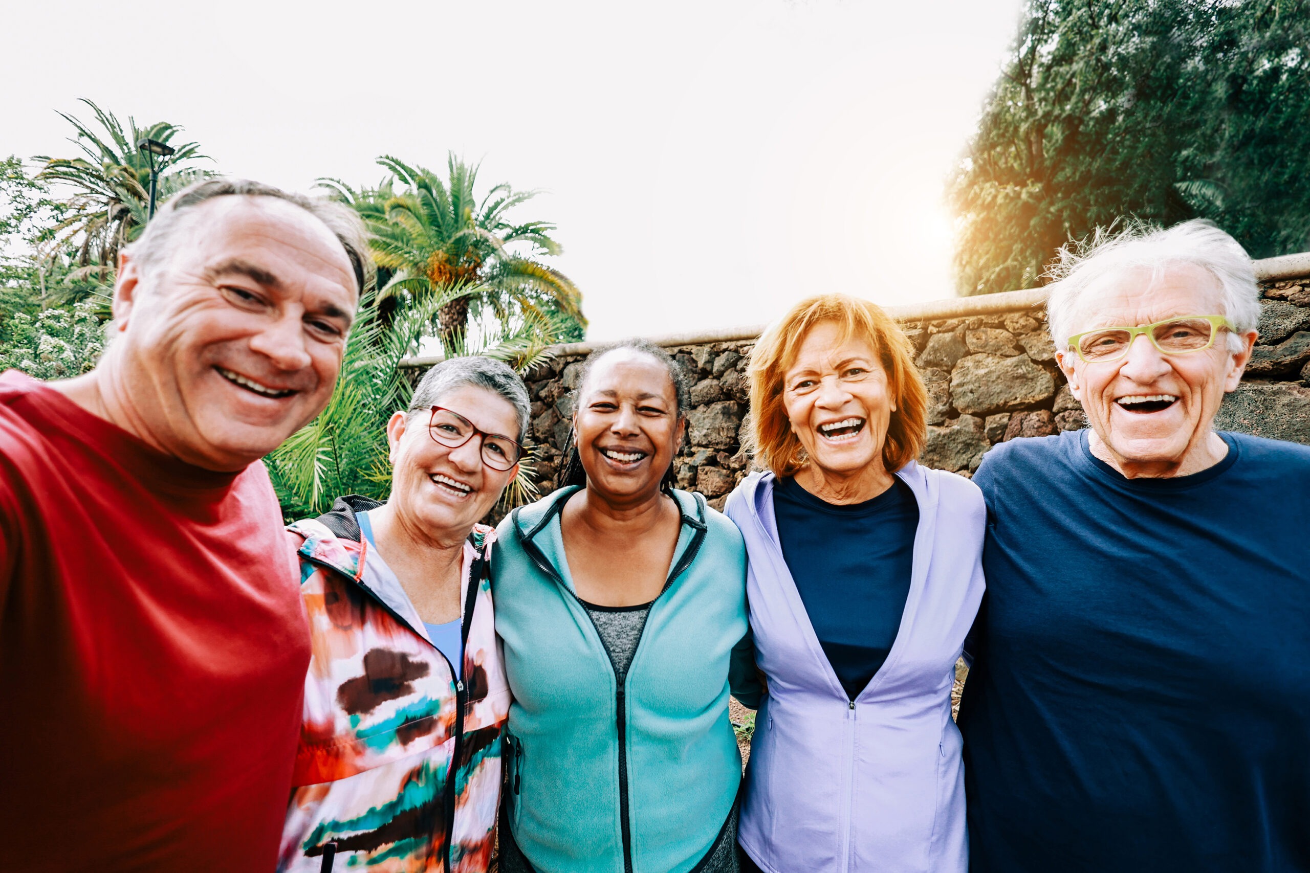 Happy sport group of senior people having fun exercising outdoors at park city - Soft focus on right old man - Multiracial elderly community concept